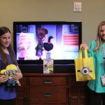 Girls with Minion toys watching a movie