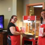 Two volunteers making popcorn for Movie Night