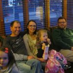 Girl with her family eating popcorn while watching a movie at Movie Night